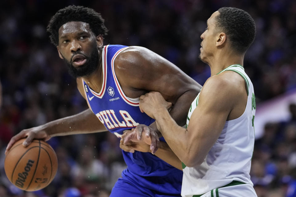 Philadelphia 76ers' Joel Embiid, left, tries to get past Boston Celtics' Malcolm Brogdon during the first half of Game 4 in an NBA basketball Eastern Conference semifinals playoff series, Sunday, May 7, 2023, in Philadelphia. (AP Photo/Matt Slocum)
