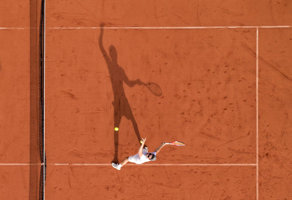 Tennis player Toby Panton practises in the late afternoon sun at Steep Lawn Tennis Club in Hampshire.