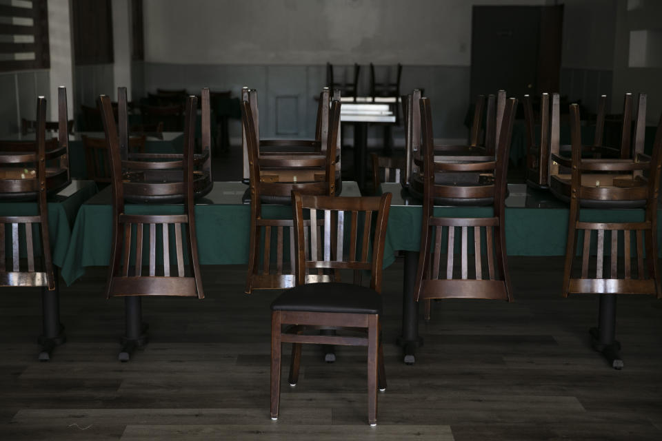 Sillas apiladas sobre las mesas en un restaurante peruano abierto solo para pedidos para llevar durante la pandemia del coronavirus, en Los Ángeles, el 6 de julio de 2020. (AP Foto/Jae C. Hong)