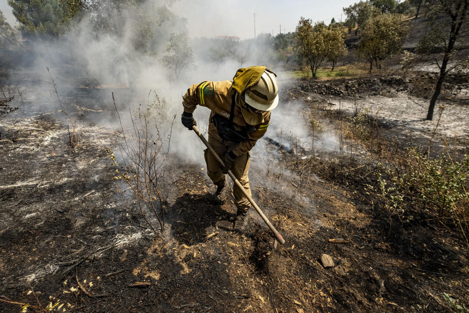 Firefighters try to extinguish a wildfire near Colos village, in central Portugal on Monday, July 22, 2019. More than 1,000 firefighters battled Monday in torrid weather against a major wildfire in Portugal, where every summer forest blazes wreak destruction. (AP Photo/Sergio Azenha)