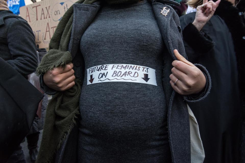 A demonstrator carries a sign during a rally in solidarity with supporters of the Women's March in Washington and many other cities on Jan. 21, 2017 in front of the Eiffel Tower in Paris.