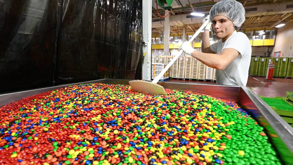 Ethan Moreno mixes candy coated chocolate at Sconza Chocolates in Oakdale, Calif., Thursday, May 30, 2024.