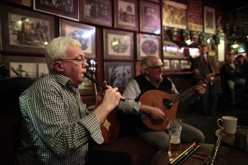 This Feb. 19, 2013 photo shows Cian O'Sullivan, left, and Tom Walsh playing music in O'Donoghue's pub in central Dublin, Ireland. The most famous pub for live "trad"' performances is O'Donoghue's, a living room-sized venue that inspired the Dubliners and Chieftains in the 1960s. (AP Photo/Peter Morrison)