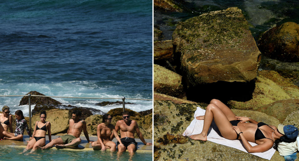 People shown lounging in swimsuits on rocks near the beach.