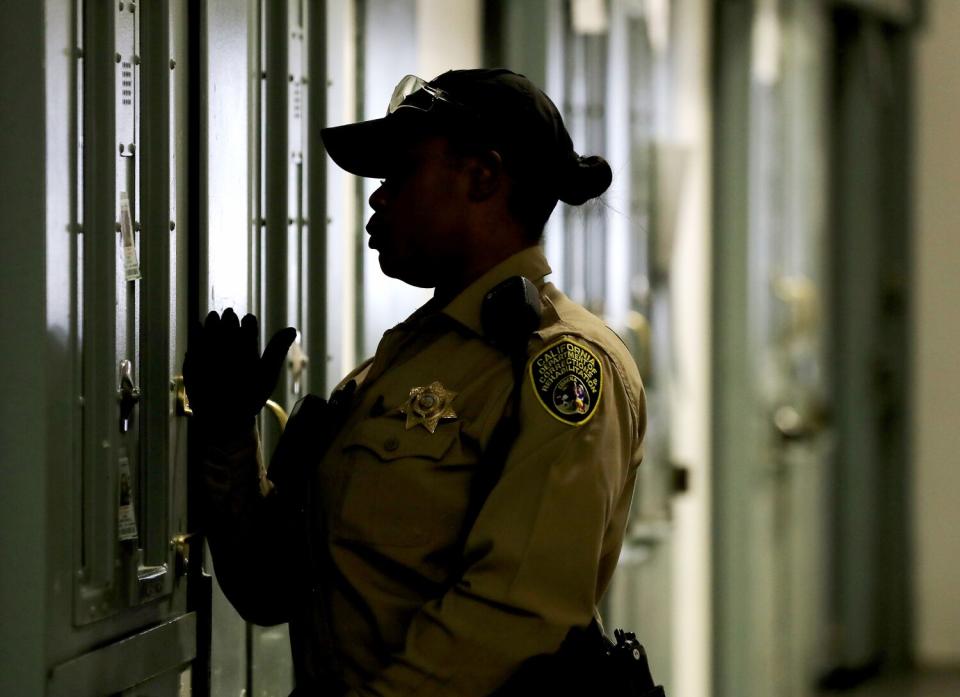 A prison guard checks on inmates at California State Prison, Sacramento.