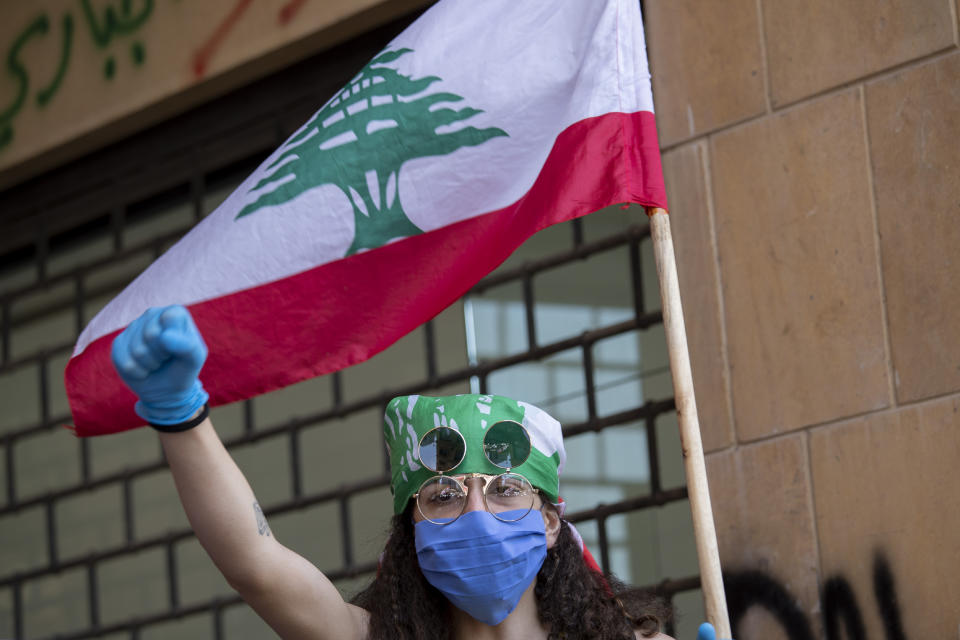 An anti-government protester shouts slogans, while wearing a mask to help curb the spread of the coronavirus, during ongoing protests in front of the Ministry of Economy, in downtown Beirut, in Beirut, Lebanon, Monday, May 18, 2020. (AP Photo/Hassan Ammar)
