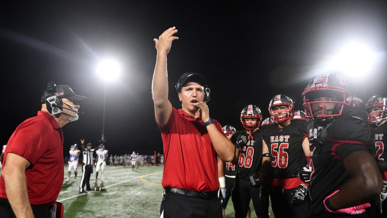 Cherry Hill East's football coach Tyler Drob, center, instructs his players during the football game between Cherry Hill East and Triton played at Cherry Hill East High School on Friday, September 13, 2024.