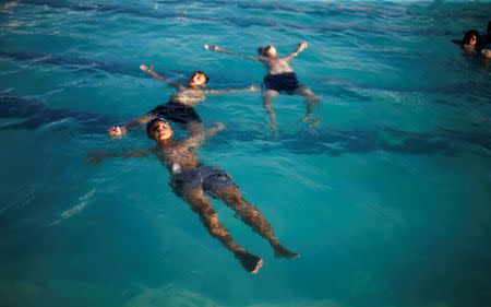 Palestinian boys swim at Sharm Park Water City, in Gaza July 9, 2018. Picture taken July 9, 2018. REUTERS/Mohammed Salem