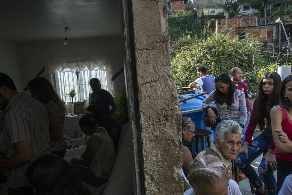 People gather at the home of Nick Samuel Oropeza for a prayer ritual in his honor in Caracas, Venezuela, Sunday, Feb. 3, 2019. The 19-year-old was found on the ground, his shirt drenched in blood, on Jan. 23, after National Guards opened fire on anti-government protesters, according to his family. (AP Photo/Rodrigo Abd)