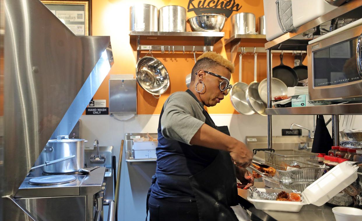 Tonya Essick, co-owner of The Plannerz Place Eatery, prepares fried chicken in her kitchen at Northside Marketplace.