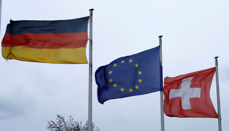 FILE PHOTO: An EU flag flies between Swiss and German national flags near the German-Swiss border in Rheinfelden, Germany, March 11, 2019. REUTERS/Arnd WIegmann/File Photo