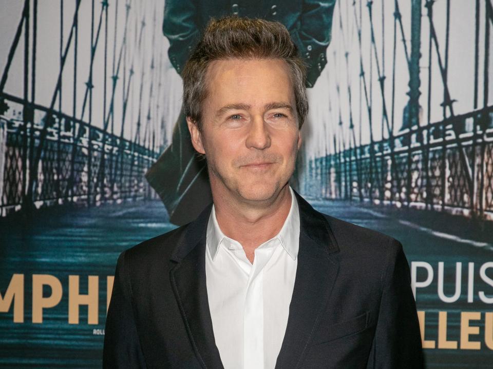 Edward Norton in front of movie poster