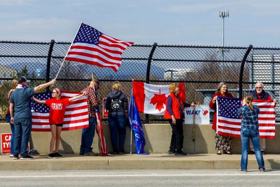 People watched from an overpass as trucks and other vehicles joined the People's Convoy of Truckers, protesting mask mandates. They were in Frederick, Maryland, headed for the U.S. Capital.