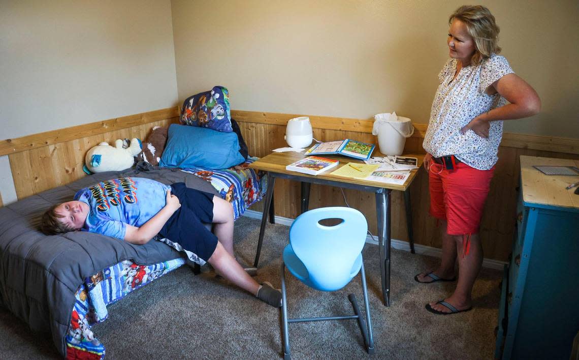 Cash Ellinger, 9, drops back onto his bed after working through a few math problems at his desk with his mother. Tricia Ellinger homeschools Cash after his school in Emmett resorted to the use of a seclusion room to control his behavior.