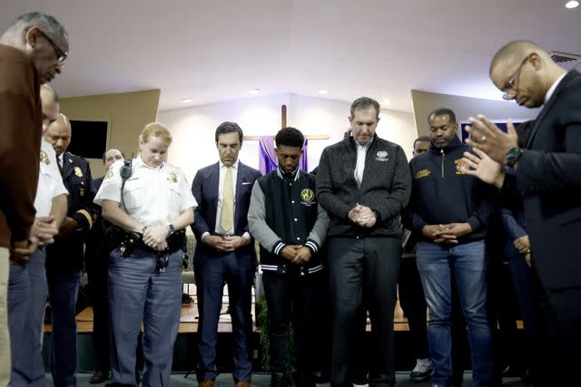 <p>Anna Moneymaker/Getty</p> Baltimore Mayor Brandon Scott is surrounded by city officials and first responders during a prayer at a vigil for victims of the Francis Scott Key Bridge collapse.