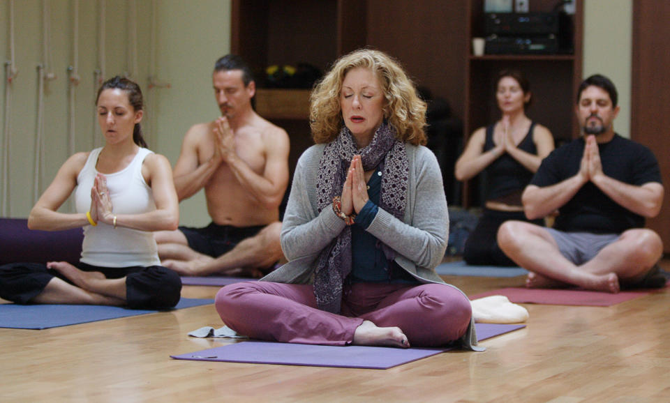 Joan Barnes (C), owner of Yoga Studio, takes a yoga class at her studio in San Francisco, California, in this March 29, 2006 file photo. Americans spend some $2.95 billion a year on yoga classes, equipment, clothing, vacations, videos and more, according to a study commissioned by monthly magazine Yoga Journal, fueled in part by aging baby boomers seeking less aggressive ways to stay fit. Roughly 16.5 million people were practicing yoga in the United States early last year, either in studios, gyms or at home, up 43 percent from 2002, the study found. To accompany feature Leisure Yoga.  REUTERS/Kimberly White/Files