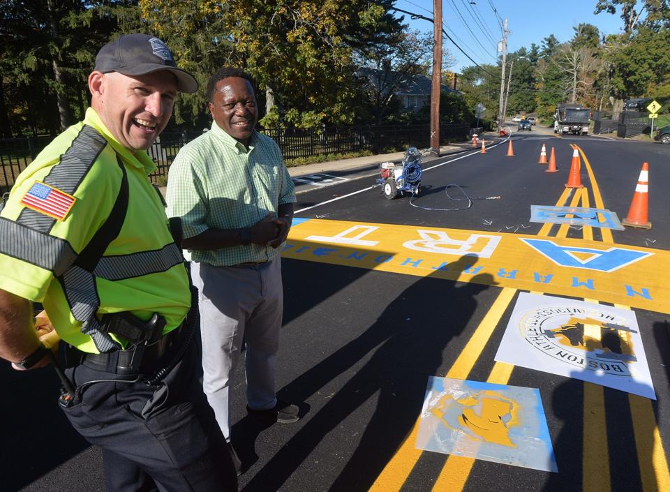 Hopkinton Town Manager Norman Khumalo, right, and police officer Kevin Sager at the painting of the start line ahead of the 125th running of the Boston Marathon, Oct. 6, 2021.