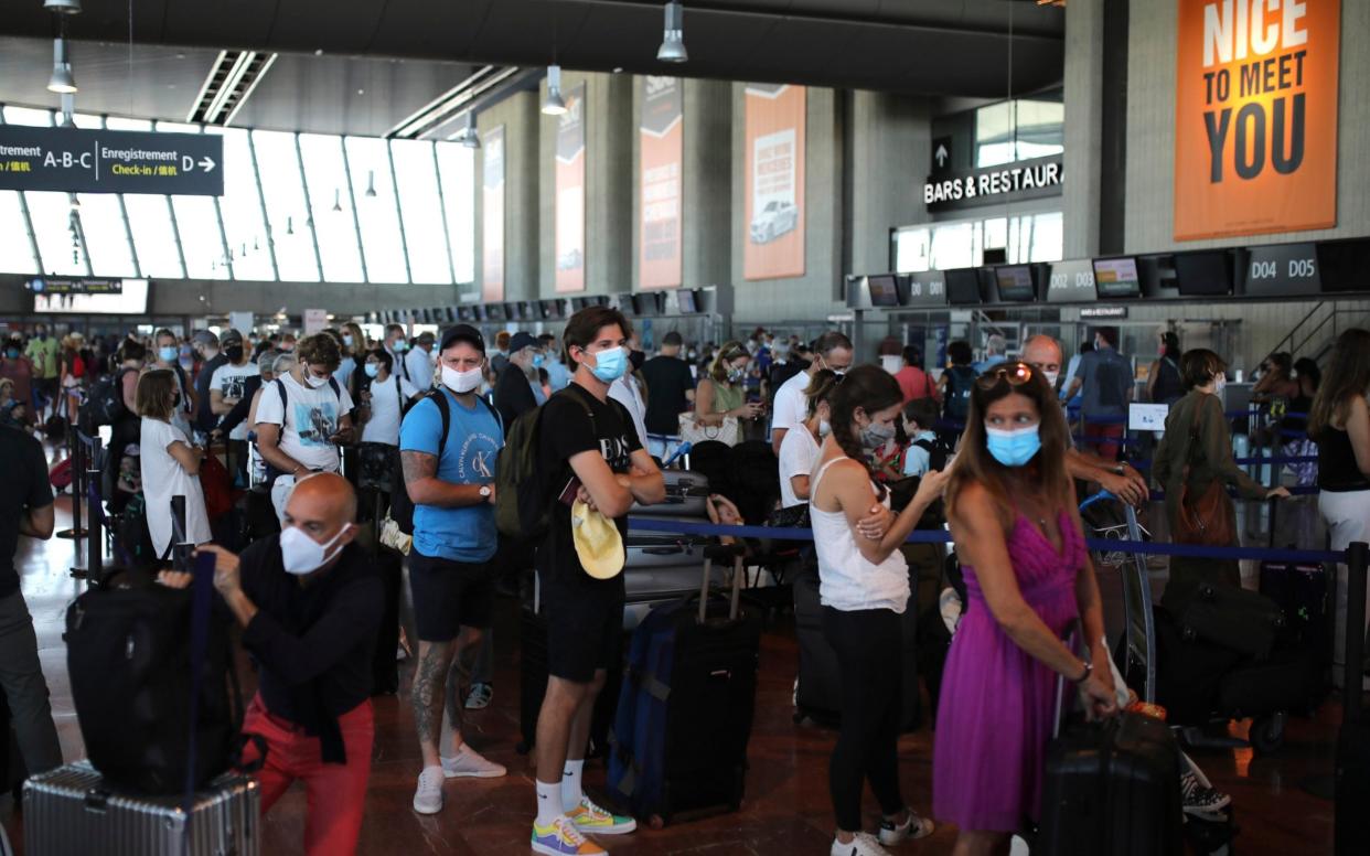 People queue in line to check-in for a British Airways flight to Heathrow airport from Nice airport - AP Photo/Daniel Cole