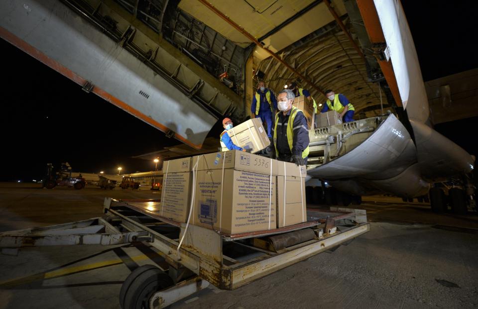 Workers at an airport outside Bishkek, Kyrgyzstan, Sunday, July 26, 2020, unload medical aid from Russia, including ventilators, to help Kyrgyzstan tackle the coronavirus outbreak. Russia has sent several medical teams and equipment to the impoverished Central Asian country. (AP Photo/Vladimir Voronin)
