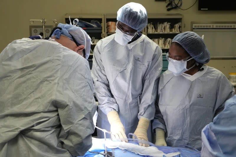 Meharry Medical College students Emmanuel Kotey, center, and Teresa Belledent, right, observe an organ recovery surgery June 15, 2023, in Jackson, Tenn. (AP Photo/Mark Humphrey)