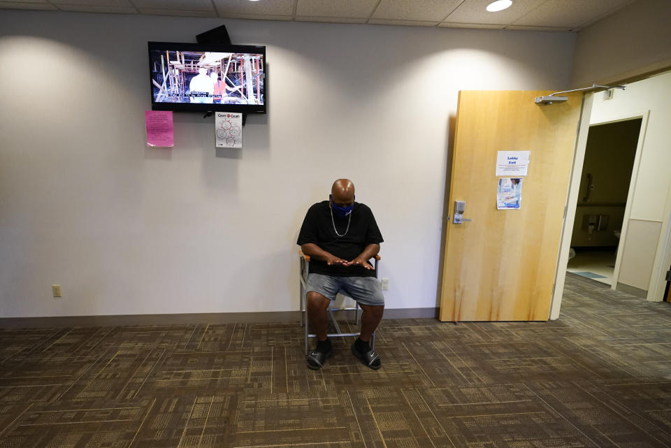 Larry Brown waits in the lobby at the Community Health Network for his occupational therapy session, Thursday, Aug. 20, 2020, in Indianapolis. The former Indiana State football player who brags about catching everything on the field now has hand therapy twice a week. (AP Photo/Darron Cummings)