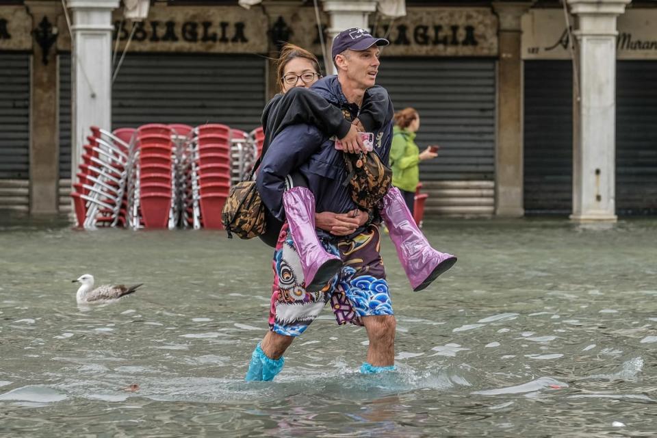 <div class="inline-image__caption"><p>A tourist wearing a bathing suit carries a woman while a seagull swims in the background in St. Mark’s Square after historical flooding inundated 85 percent of the city. </p></div> <div class="inline-image__credit">Stefano Mazzola/Awakening/Getty</div>