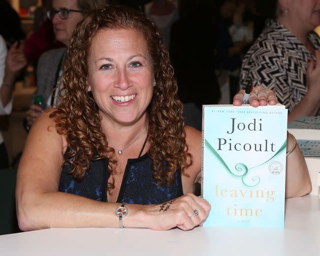 Author Jodi Picoult holds up her novel, 