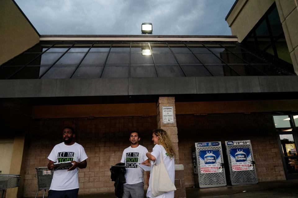 Canvassers Curtis Duncan, left, Gabriel Sanchez, center, and Sienna Giraldi, right, wait to talk with Atlanta residents on July 20 in Atlanta.