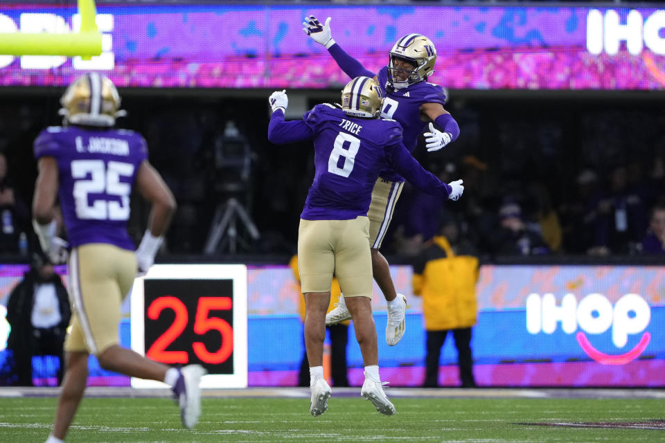Washington cornerback Thaddeus Dixon, jumps up to celebrate his interception against Washington State with teammate Bralen Trice (8) during the first half of an NCAA college football game Saturday, Nov. 25, 2023, in Seattle. (AP Photo/Lindsey Wasson)