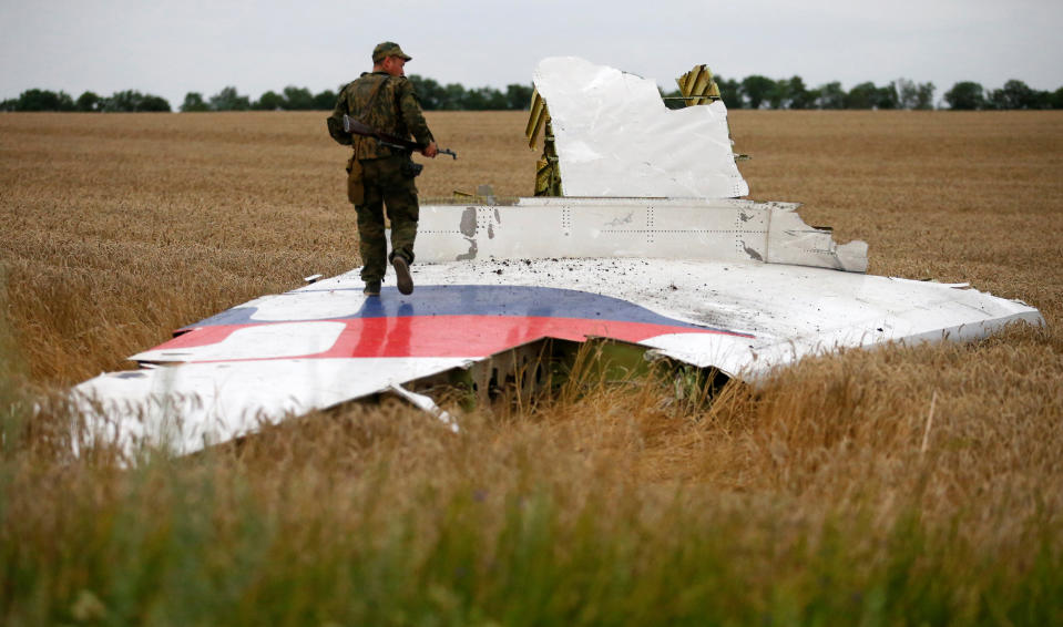 An armed pro-Russian separatist stands on part of the wreckage of the Malaysia Airlines Boeing 777 plane after it crashed near the settlement of Grabovo in the Donetsk region, July 17, 2014. The Dutch are due to announce on Wednesday 28 September the long-awaited results of an investigation with Australia, Malaysia, Belgium and Ukraine into the July 17, 2014 downing of the flight.    REUTERS/Maxim Zmeyev/File Photo          FROM THE FILES PACKAGE - SEARCH "FILES MH17" FOR ALL 20 IMAGES