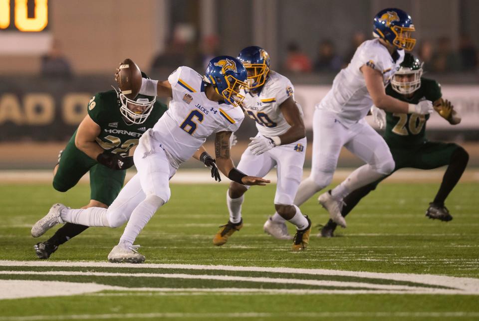 South Dakota State quarterback Chris Oladokun (6) gets away from Sacramento State linebacker Jeremy Harris, left, while scrambling to end up with a large gain during the second quarter of a second-round NCAA FCS college football playoff game Saturday, Dec. 4, 2021, in Sacramento, Calif.