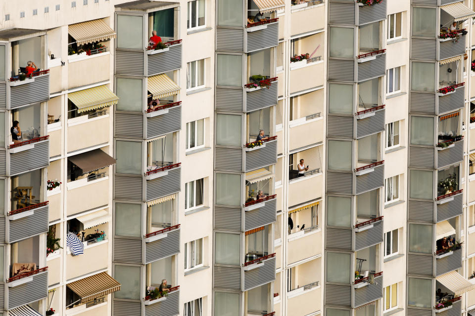 Residents on their balconies listen to a concert featuring distant harmonies, at a time when cultural events have been disrupted by the coronavirus pandemic, in the Prohlis neighborhood in Dresden, Germany, Saturday, Sept. 12, 2020. About 33 musicians of the Dresden Sinfoniker perform a concert named the 'Himmel ueber Prohils', The Sky above Prohlis, on the roof-tops of communist-era apartment blocs in the Dresden neighborhood Prohlis. (AP Photo/Markus Schreiber)