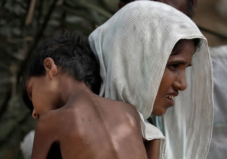 A woman carries her ill child in a refugee camp at Cox's Bazar, Bangladesh, September 26, 2017. REUTERS/Cathal McNaughton