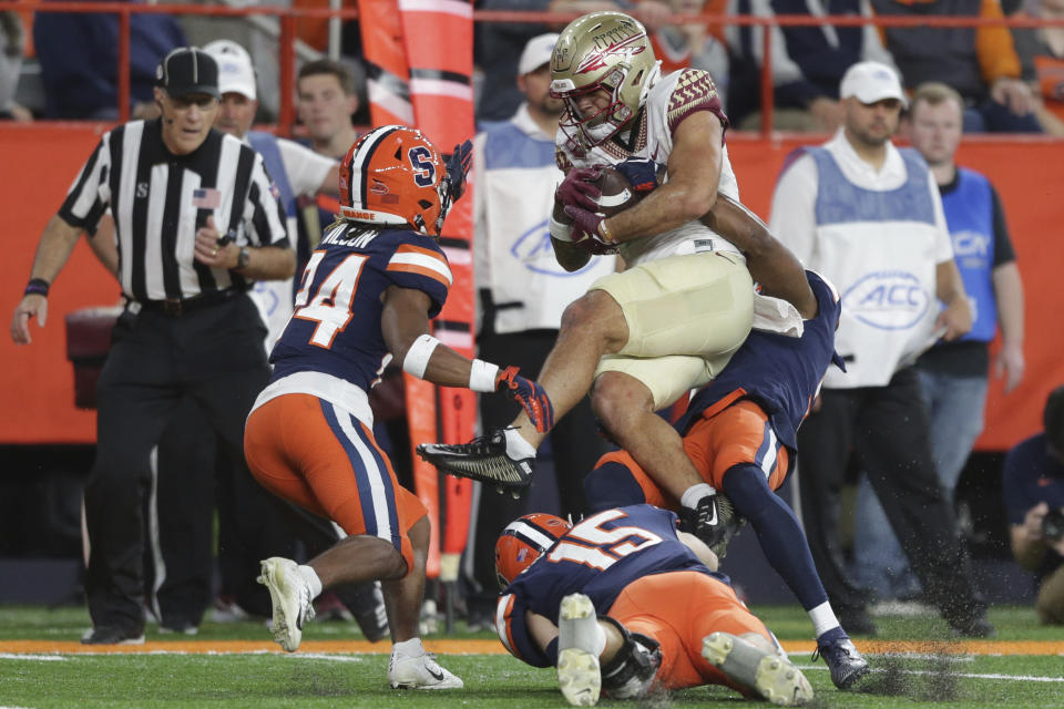 Syracuse defensive back Alijah Clark, defensive back Jeremiah Wilson (24), and linebacker Derek McDonald (15) tackle Florida State wide receiver Mycah Pittman during the first half of an NCAA college football game Saturday, Nov. 12, 2022, in Syracuse, N.Y. (AP Photo/Joshua Bessex)