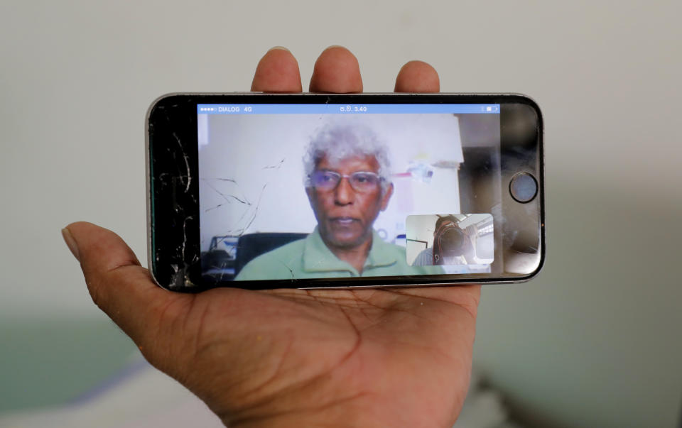 In this Nov. 6, 2019 photo, self exiled Sri Lankan journalist and media rights activist Sunanda Deshapriya is seen on a mobile phone screen during a skype call in Colombo, Sri Lanka.Forced to flee their country a decade ago to escape allegedly state-sponsored killer squads, Sri Lankan journalists living in exile doubt they’ll be able to return home soon or see justice served to their tormentors _ whose alleged ringleader could come to power in this weekend’s presidential election. Exiled journalists and media rights groups are expressing disappointment over the current government’s failure in punishing the culprits responsible for crimes committed against media members. (AP Photo/Eranga Jayawardena)