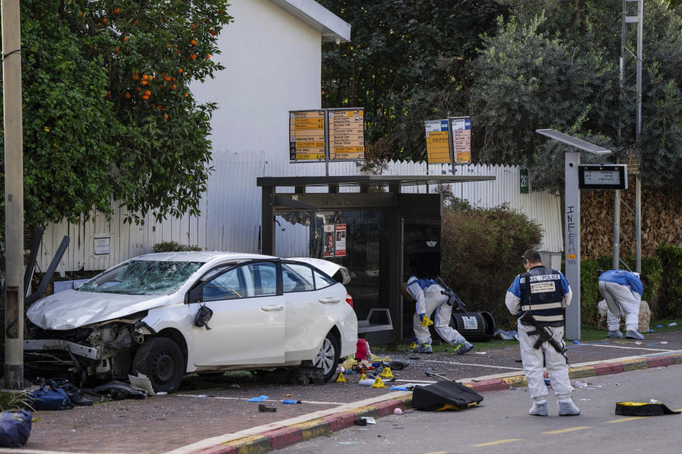 Israeli security forces work at the site of a Palestinian car-ramming and stabbing attack at a bus stop, in Ra'anana, Israel, Monday, Jan. 15, 2024. Israeli police say a car-ramming and stabbing attack by Palestinians killed a woman and wounded at least 12 others north of Tel Aviv. (AP Photo/Oded Balilty)