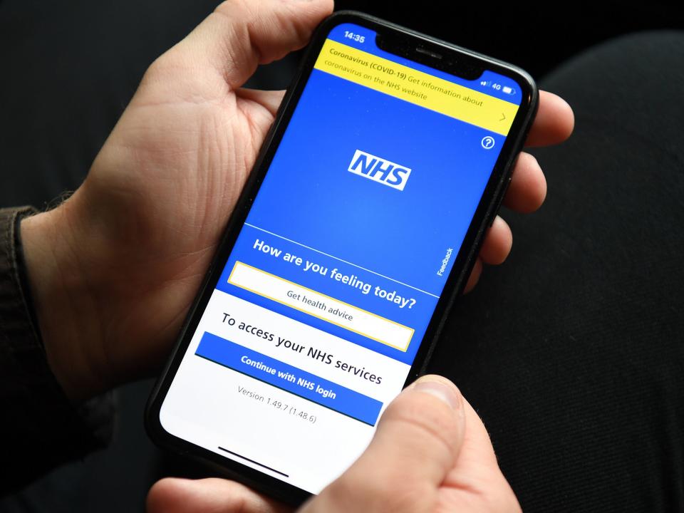 A person holding a mobile phone displaying the NHS app. The NHS app will be used by holidaymakers in England to prove their coronavirus status to destination countries, Transport Secretary Grant Shapps has announced (PA)