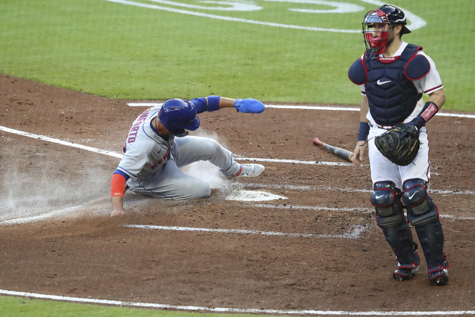 New York Mets' Michael Conforto scores past Atlanta Braves catcher Travis D'Arnaud on a single by Robinson Cano during the third inning of a baseball game Monday, Aug. 3, 2020,, in Atlanta. (Curtis Compton/Atlanta Journal-Constitution via AP)