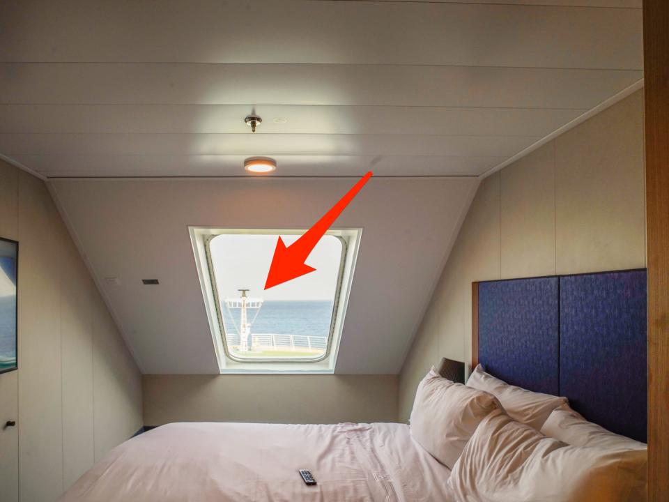 An arrow points to the front of the ship out the window in a stateroom