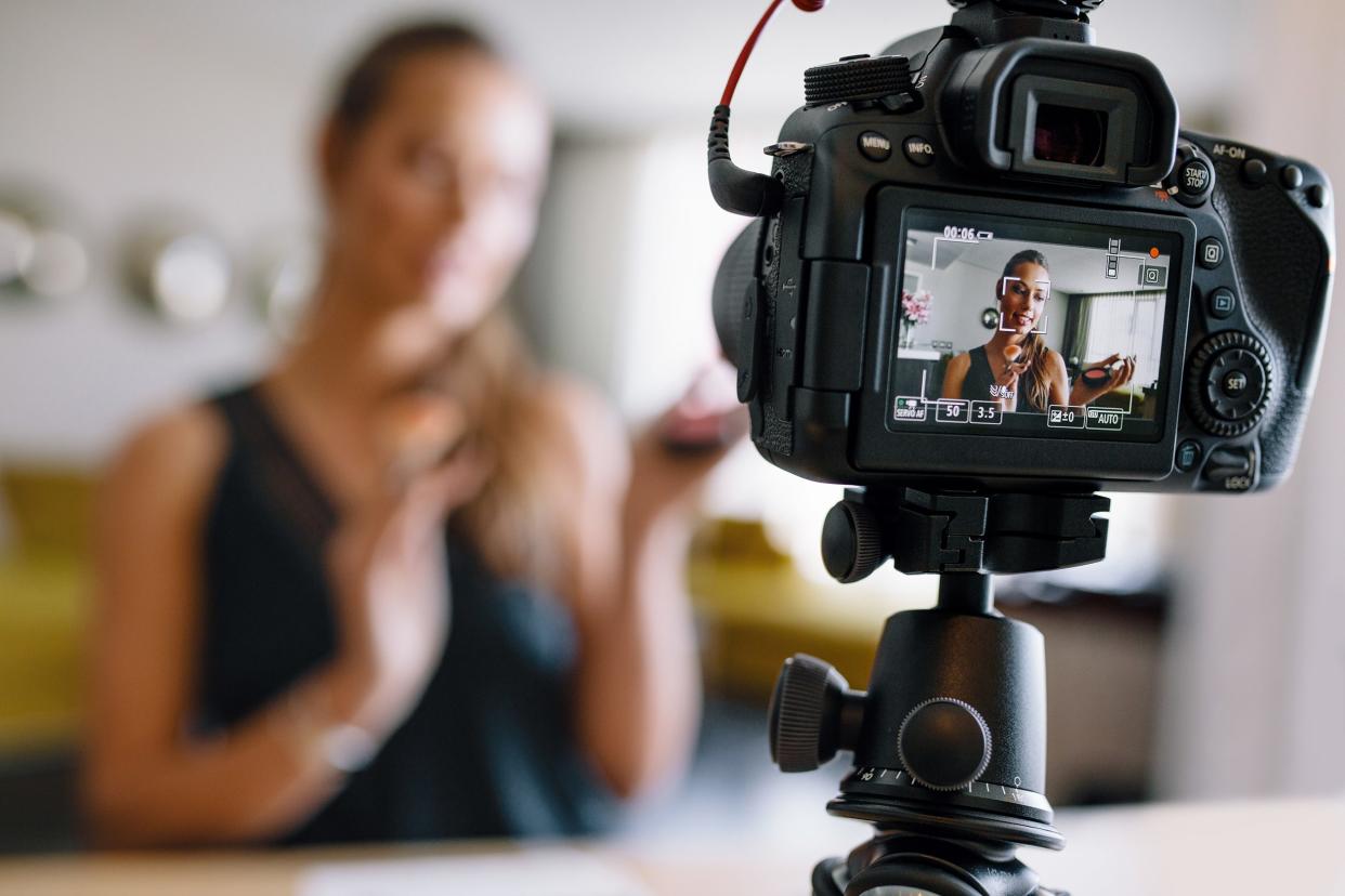 female vlogger recording a make-up video for her vlog