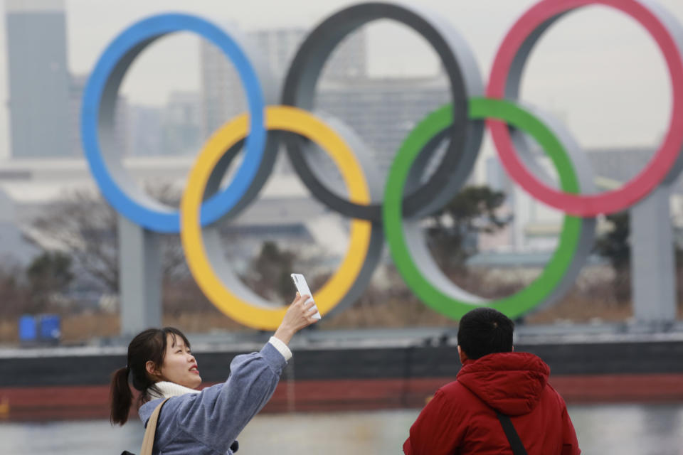 A woman poses for a selfie in front of Olympic rings at Odaiba waterfront in Tokyo, Tuesday, Jan. 26, 2021. The postponed Tokyo Games are scheduled to open on July 23. (AP Photo/Koji Sasahara)