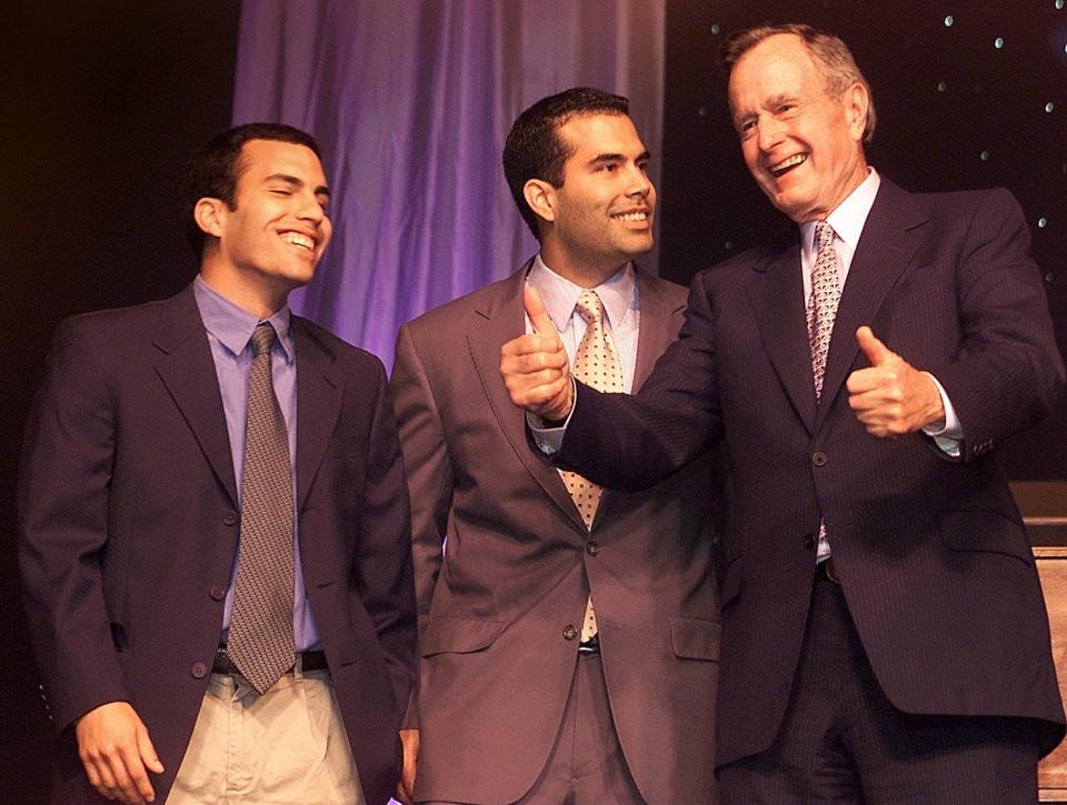 John "Jebby" Bush, and brother George P. Bush watch their grandfather, former President George H. W. Bush, give a "thumbs up" sign at Governor Jeb Bush's Inauguration Party.