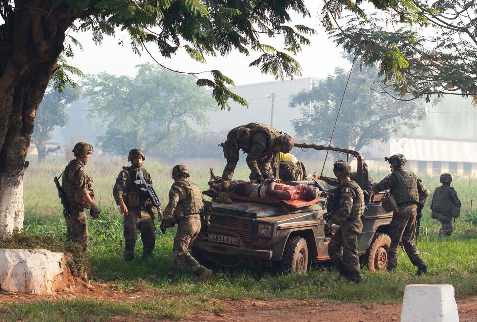 FILE - In this Monday, Dec. 23, 2013 file photo, French soldiers lay a wounded man, who had been attacked during a protest, atop a military vehicle as they take him to get medical help, at Mpoko Airport in Bangui, Central African Republic. Sub-Saharan Africa has seen a very violent start to 2014 with raging conflicts in South Sudan and Central African Republic - the death tolls are huge and the individual incidents gruesome, with one estimate saying nearly 10,000 have been killed in South Sudan in a month of warfare. (AP Photo/Rebecca Blackwell, File)