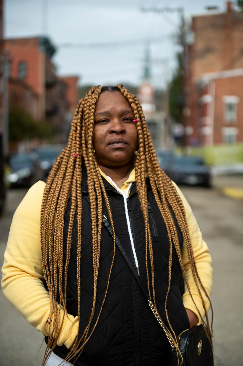 Mary Pouncy, 48, poses for a portrait in the Over the Rhine neighborhood of Cincinnati on Sunday, Oct. 25, 2020. Pouncy decorated the window of her apartment with hand drawn Biden/Harris decorations.