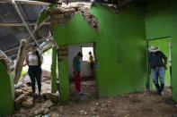 Miembros de una familia observan los destrozos causados por un deslizamiento provocado por los huracanes Eta y Iota en La Reina (Honduras) el 25 de junio del 2021. (AP Photo/Rodrigo Abd, File)