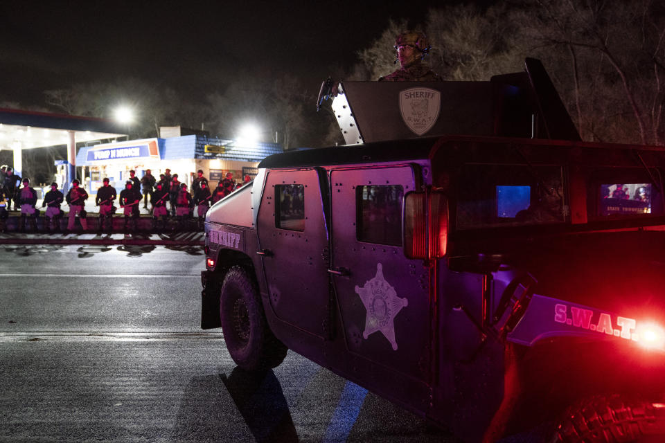 Authorities advance into a gas station after pursuing demonstrators for violating curfew and issuing orders to disperse during a protest against the police shooting of Daunte Wright, late Monday, April 12, 2021, in Brooklyn Center, Minn. (AP Photo/John Minchillo)