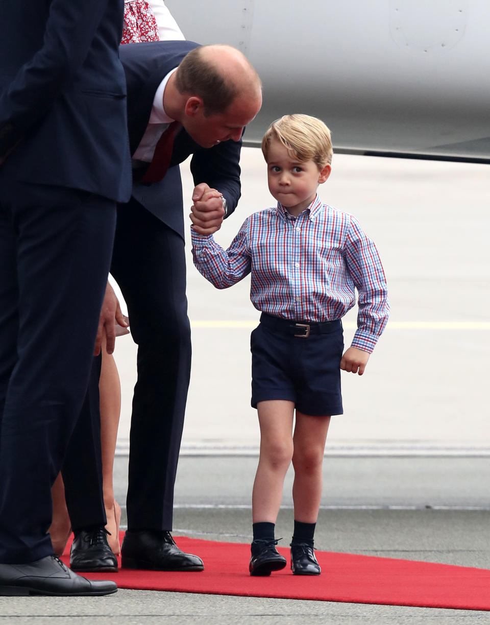 Prince William speaks with Prince George of Cambridge as they arrive on the first day of their official visit to Poland on July 17, 2017.