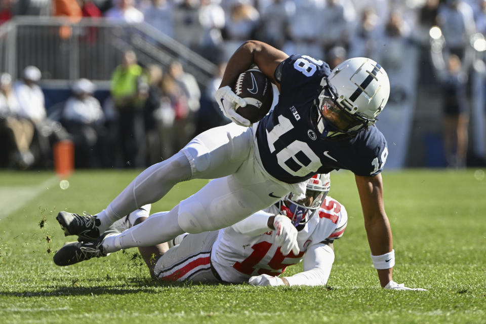 Ohio State safety Tanner McCalister (15) tackles Penn State wide receiver Omari Evans (18) during the secomd half of an NCAA college football game, Saturday, Oct. 29, 2022, in State College, Pa. (AP Photo/Barry Reeger)