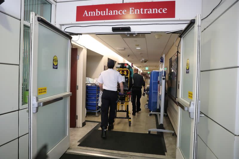 An ambulance crew rushes a coronavirus disease (COVID-19) patient into the emergency department at Providence Mission Hospital in Mission Viejo