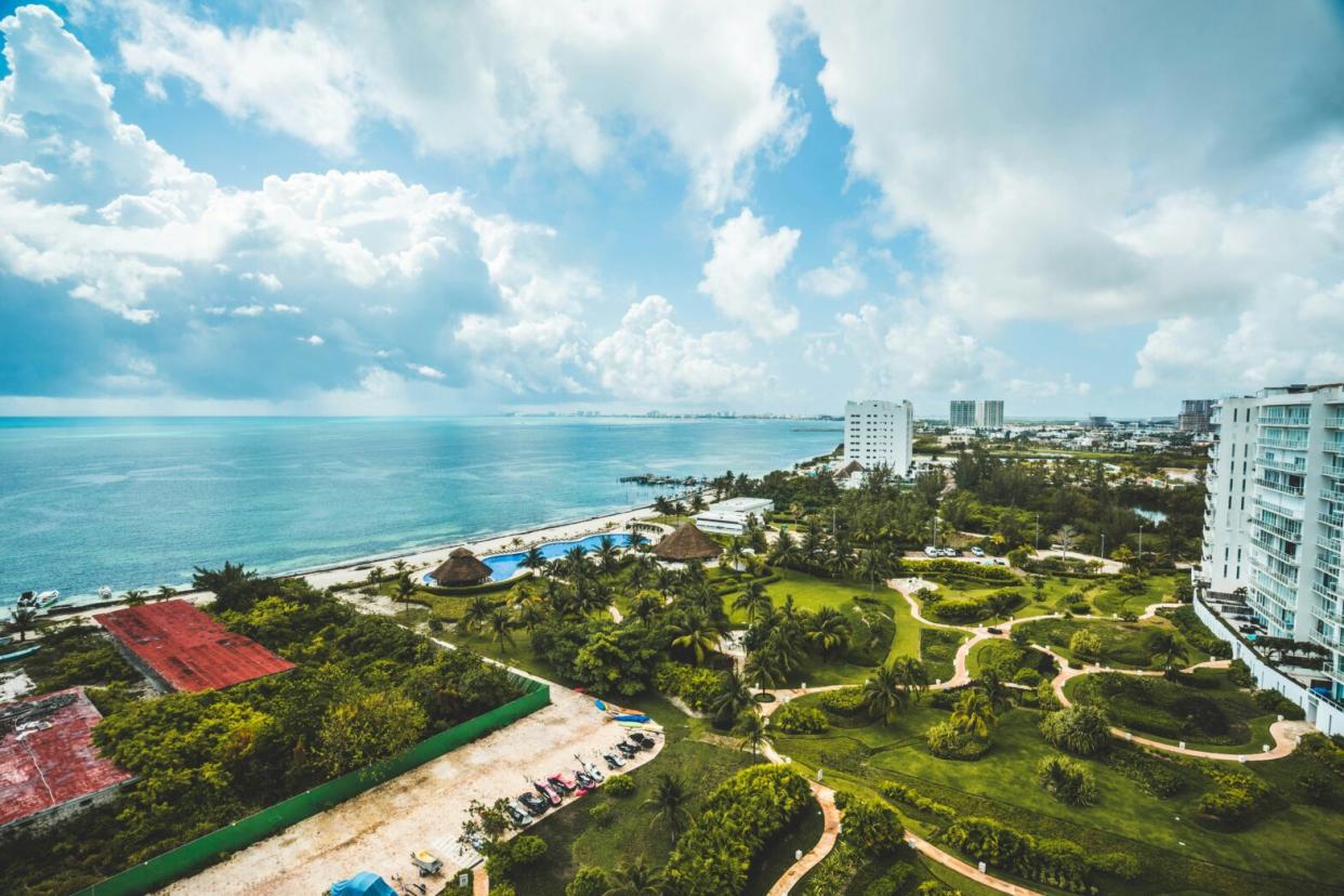 downtown Cancun is an underrated destination that has plenty to do. Check out the top activities and attractions. pictured: view of Cancun's coast with lush green lands that transition into bright blue waters